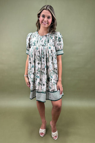 Woman wearing a floral dress against a green background