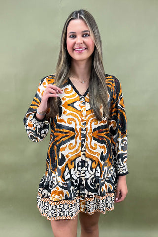 Woman wearing a patterned dress against a green background