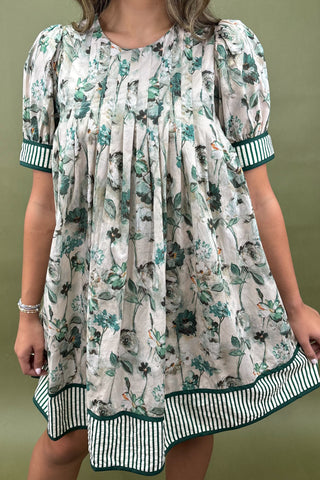 Woman wearing a floral dress against a green background
