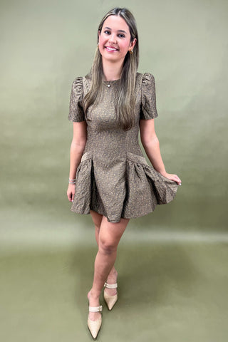 Woman wearing a patterned dress against a green background