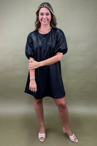 Woman wearing a black dress against a green background