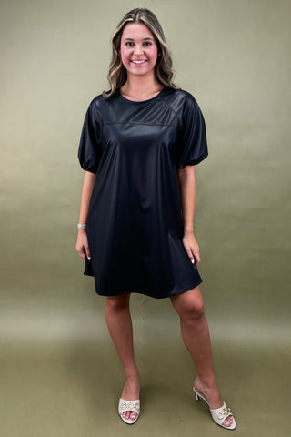 Woman wearing a black dress against a green background