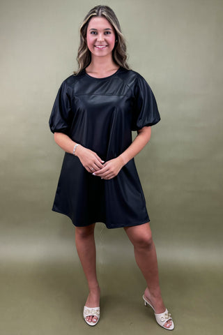 Woman wearing a black dress against a green background