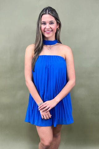 Woman wearing a blue dress against a green background