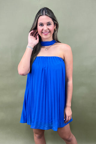 Woman wearing a blue dress against a green background