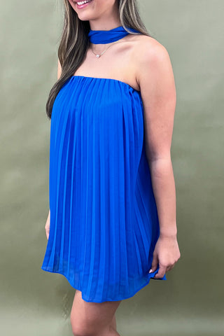 Woman wearing a blue dress against a green background