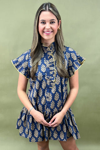 Woman wearing a blue floral dress against a green background