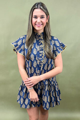 Woman wearing a blue floral dress against a green background