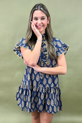 Woman wearing a blue floral dress against a green background