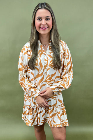 Woman wearing a patterned dress against a green background