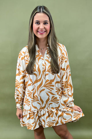 Woman wearing a patterned dress against a green background