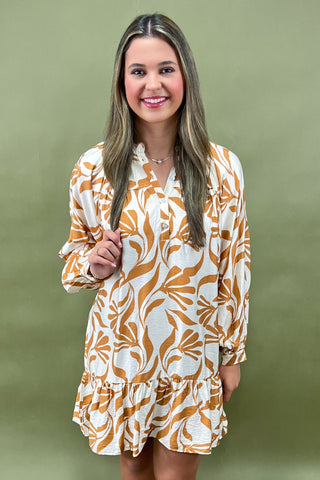Woman wearing a patterned dress against a green background