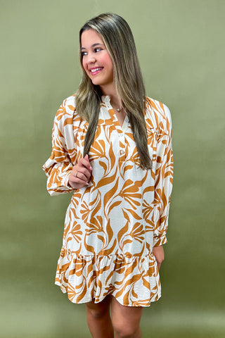 Woman wearing a patterned dress against a green background