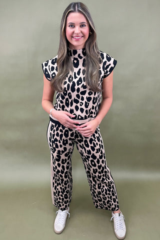 Woman wearing a leopard print outfit against a plain background