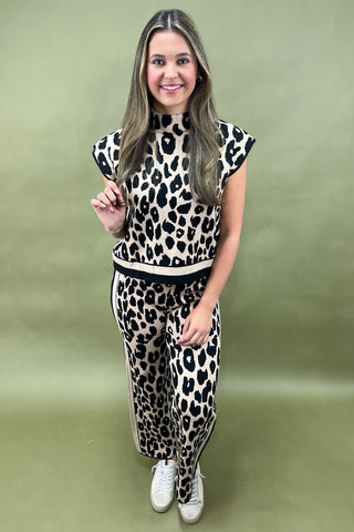 Woman wearing a leopard print outfit on a green background