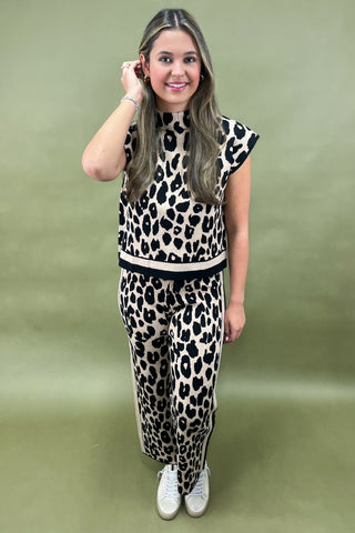 Woman wearing a leopard print outfit on a green background