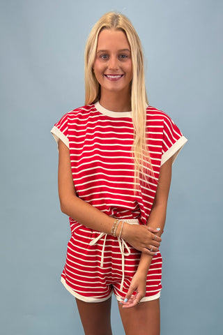 Woman wearing a red and white striped outfit against a gray background