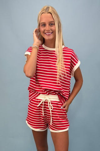 Woman wearing a red and white striped outfit against a gray background