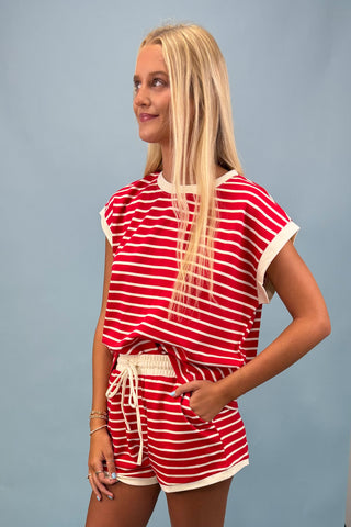 Woman wearing a red and white striped outfit against a gray background