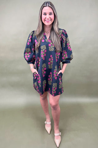 Woman wearing a floral dress against a plain background
