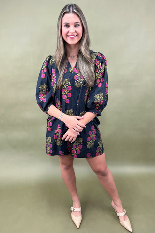 Woman wearing a floral dress against a green background