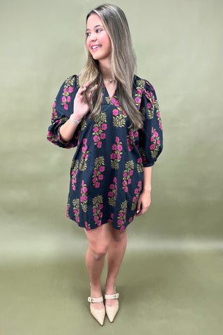 Woman wearing a floral dress on a plain background