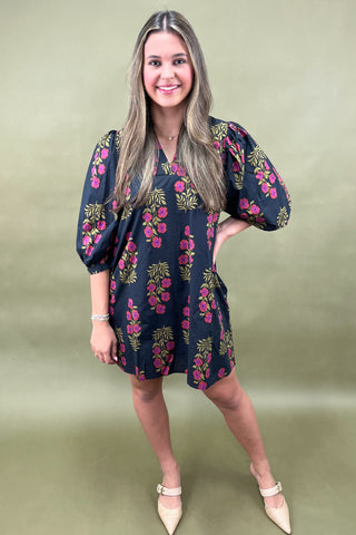 Woman wearing a floral dress on a green background