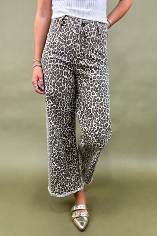 Person wearing leopard print pants on a plain background