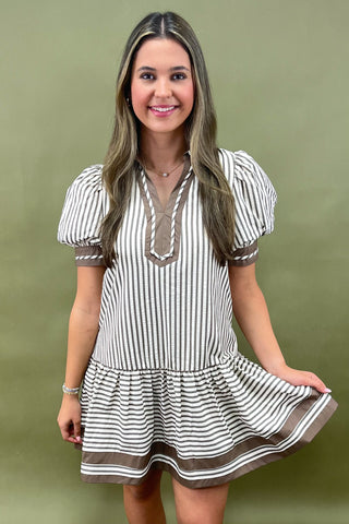 Woman wearing a striped dress against a green background