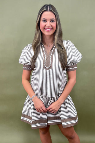 Woman wearing a striped dress against a green background
