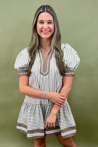 Woman wearing a striped dress against a green background