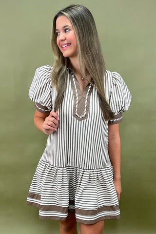 Woman wearing a striped dress with a green background
