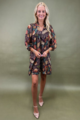Woman wearing a floral dress against a plain background