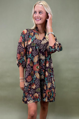 Woman wearing a floral dress with a plain background