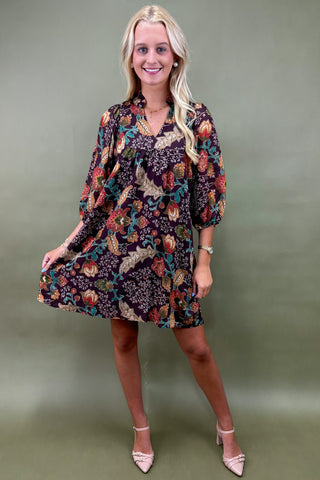 Woman wearing a floral dress against a green background