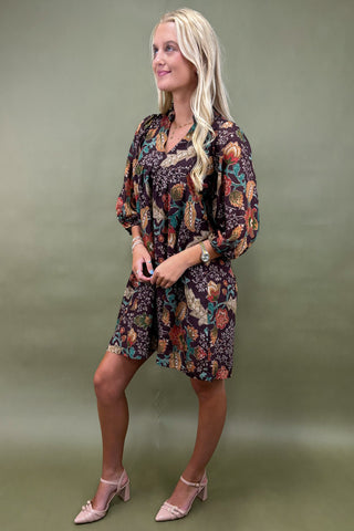 Woman wearing a floral dress against a green background