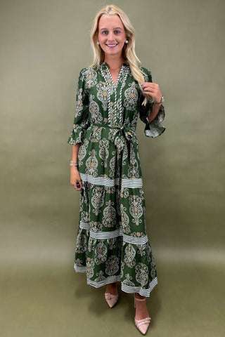 Woman wearing a green patterned dress against a plain background