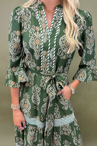 Green patterned dress worn by a person on a plain background