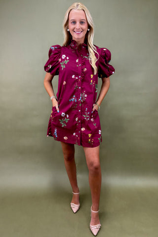 Woman wearing a purple textured top with white trim against a plain background