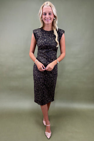 Woman wearing a black patterned dress against a plain background