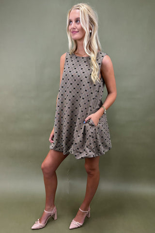 Woman wearing a patterned dress against a plain background