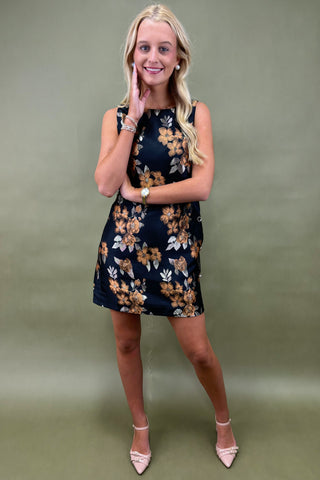 Woman wearing a floral dress against a plain background