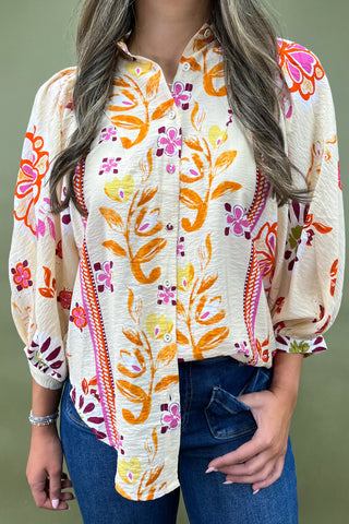 Woman wearing a colorful floral blouse with a green background