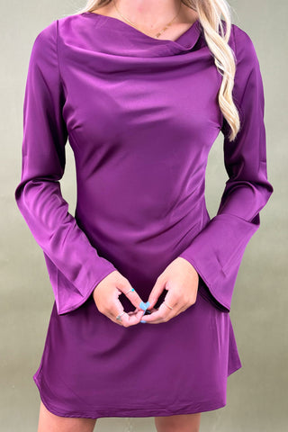 Purple long-sleeve dress worn by a person on a plain background