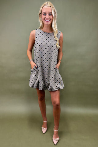 Woman wearing a polka dot dress against a green background