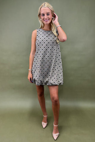 Woman wearing a patterned dress against a plain background