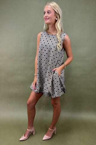 Woman wearing a polka dot dress against a green background