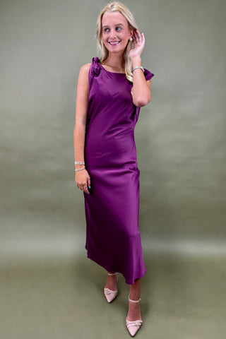 Woman wearing a purple dress against a plain background