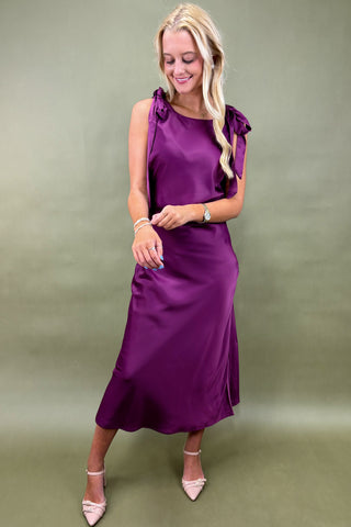 Woman wearing a purple dress against a green background