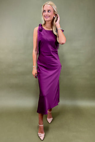 Woman wearing a purple dress against a green background